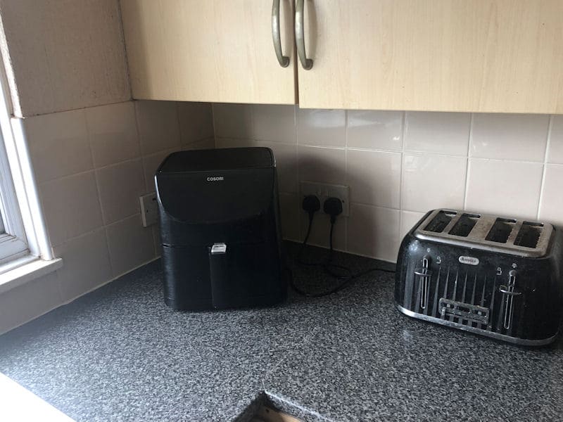 Air fryer located in corner of kitchen worktop, under cabinets