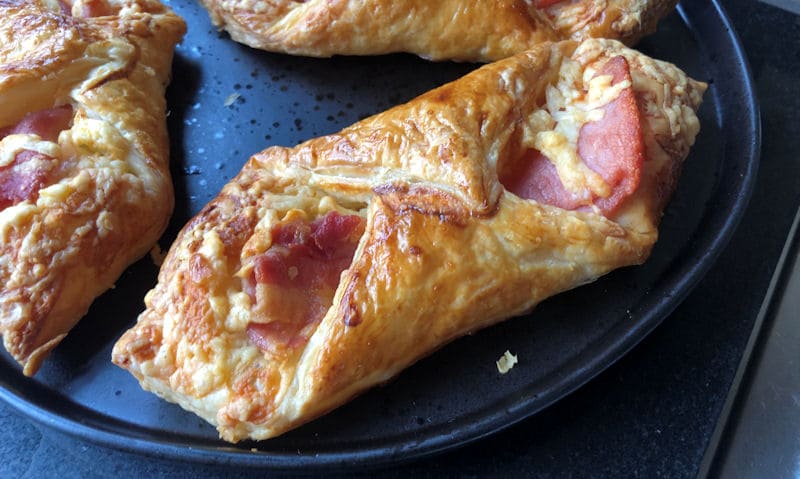 Plate of golden rich crispy crust bacon and cheese turnovers