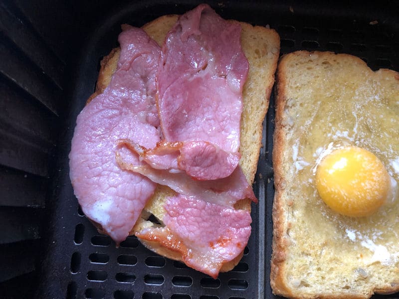 Partially air fried bacon rashers positioned on second bread slice