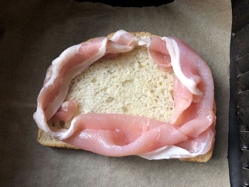 Raw bacon rasher nest on bread slices