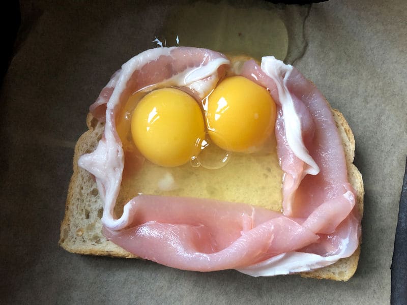 Raw eggs poured into middle of raw bacon nest