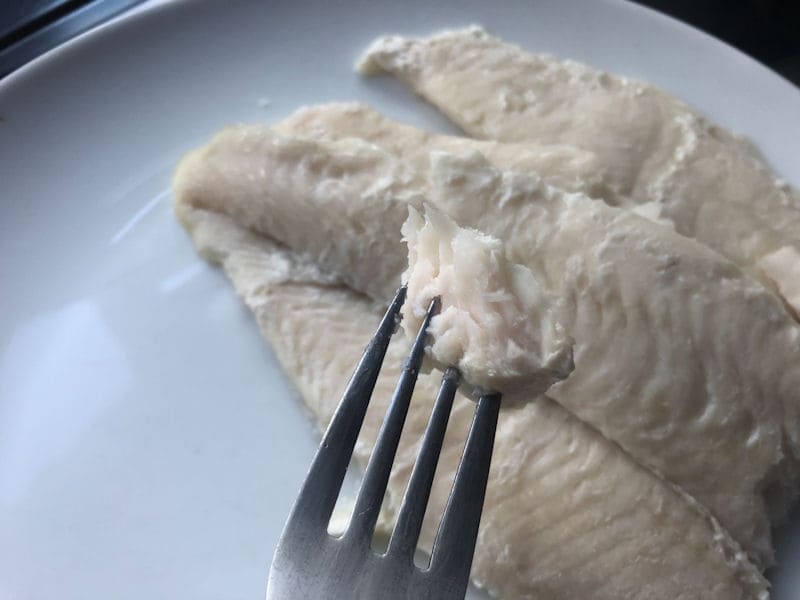 Basa fillet flakes visible up close with fish on fork