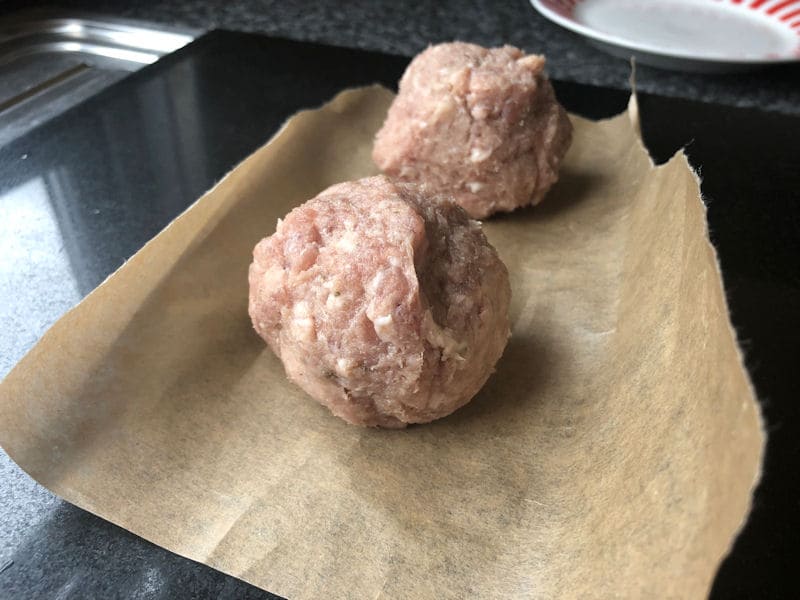 Pork sausage balls on parchment paper, chopping board