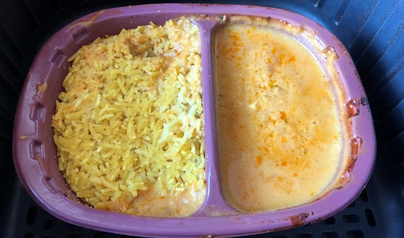 Two compartment Chicken Korma ready meal sat in air fryer basket