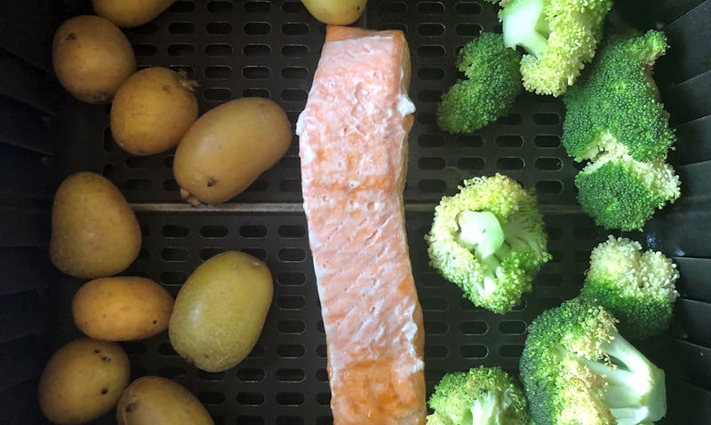 Salmon fillet, small broccoli florets and potatoes in air fryer basket