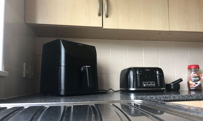 View of my air fryer under cabinets, shared area with toaster