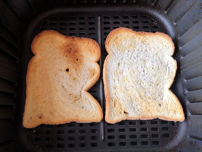 Toasted bread with brown crunchy texture inside air fryer basket