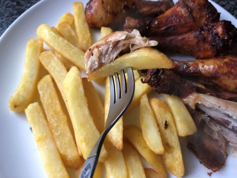 Spoonful of barbeque chicken and chips on fork