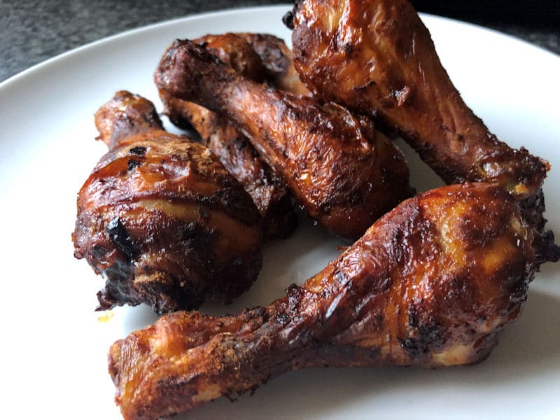 Stack of BBQ chicken drumsticks on plate