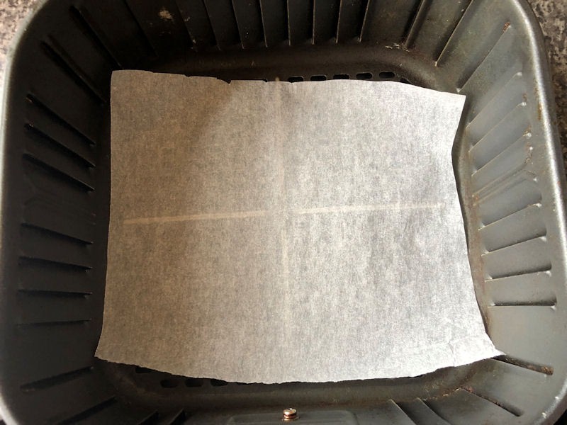 Cut to size sheet of parchment paper in air fryer basket