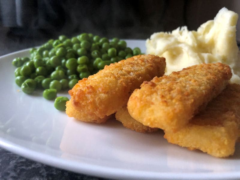 Breaded fish fingers served with buttery mash potatoes and peas