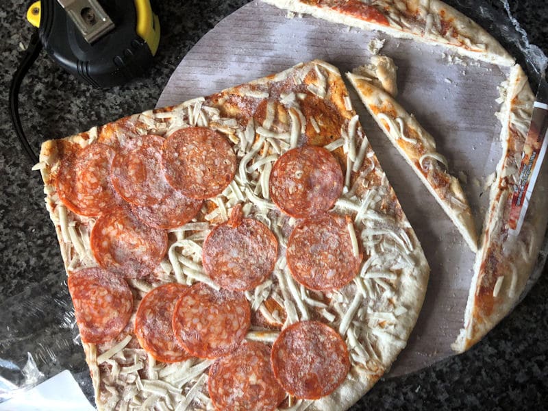 Cut up frozen pizza edges sitting on parchment paper