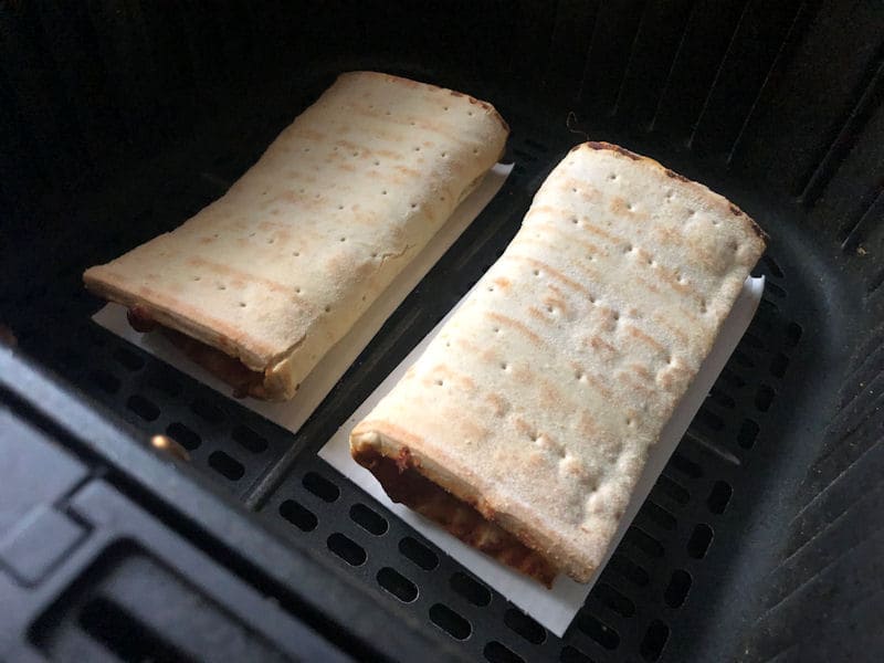 Frozen pizza pockets positioned in air fryer basket