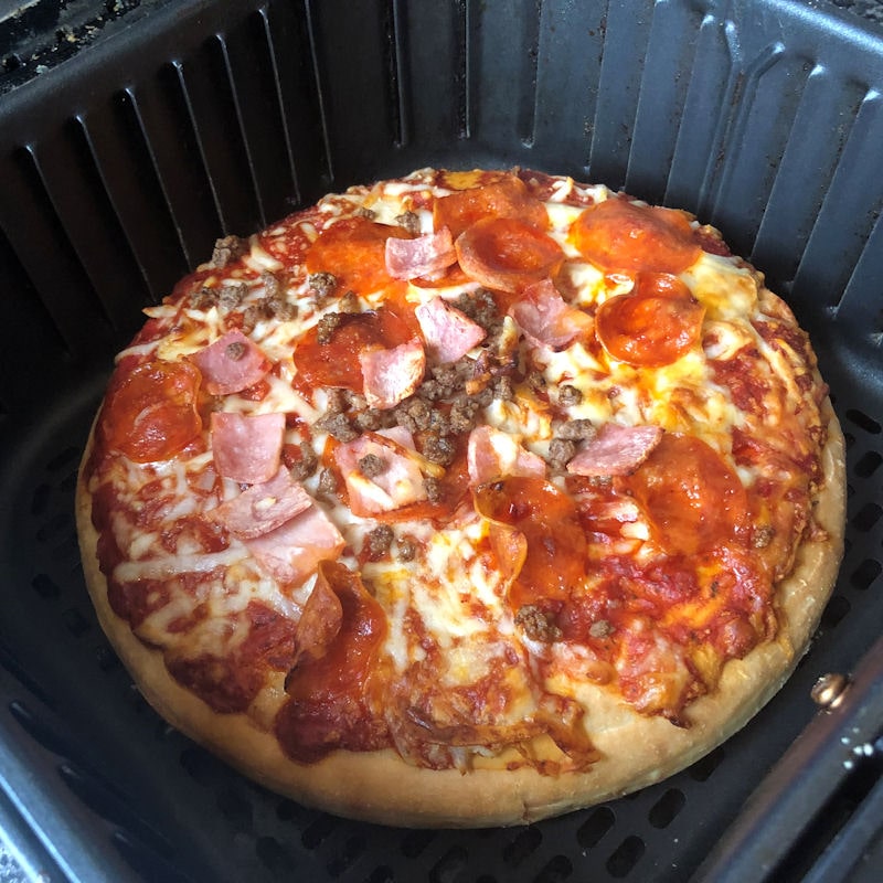 Scale of pizza is seen in small air fryer basket