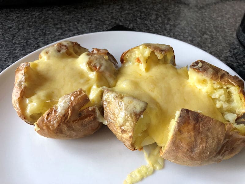 Melting Cheddar cheese over 2 plated pre-cut jacket potatoes