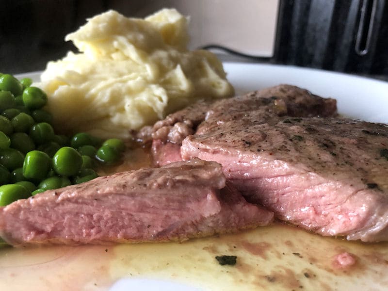 Medium rare air fried Lamb Leg Steak with mash potatoes and peas