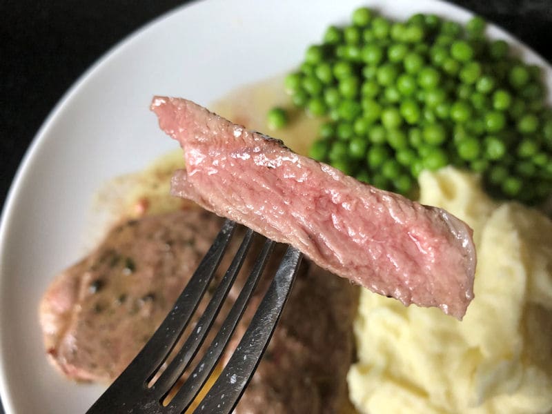 Cut of air fried medium rare lamb leg steak on fork