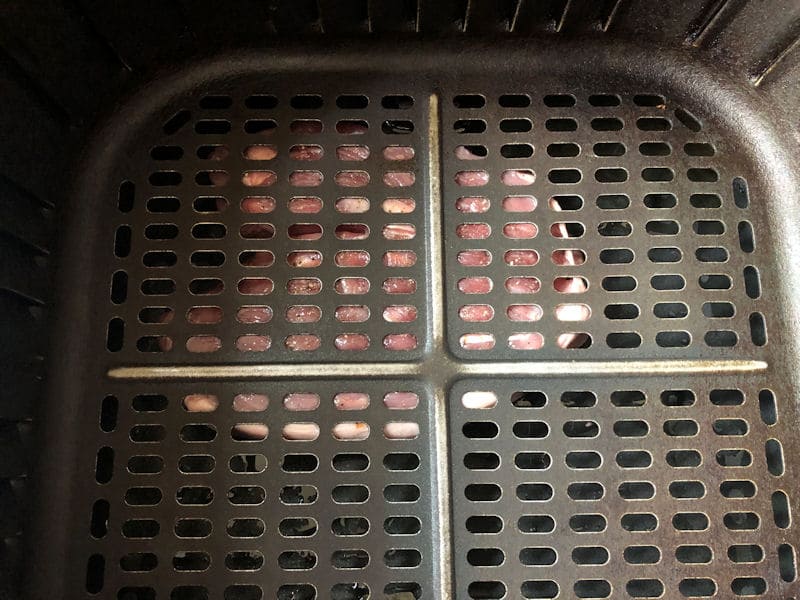 How lamb leg steak looks pressed in between air fryer basket and container