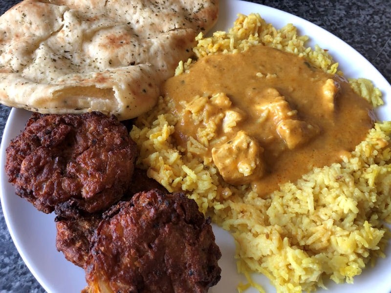 Air fried Chicken Korma ready meal with onion bhajis, naan bread on dinner plate