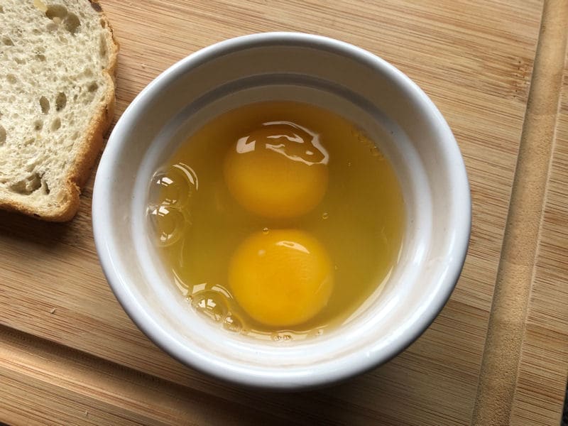 Eggs cracked into single ceramic ramekin