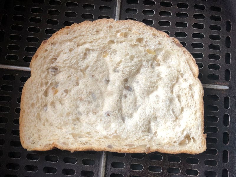 Slice of bread positioned in bare air fryer basket