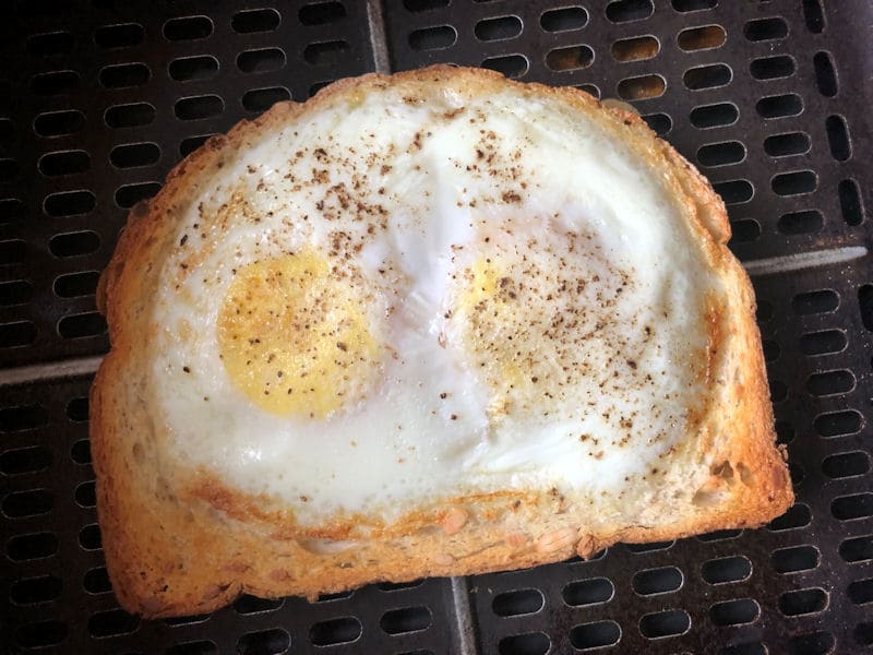 Cooked eggs on toast in air fryer with crispy golden toast