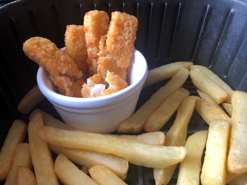 Fish fingers stood up in ceramic ramekin inside air fryer basket