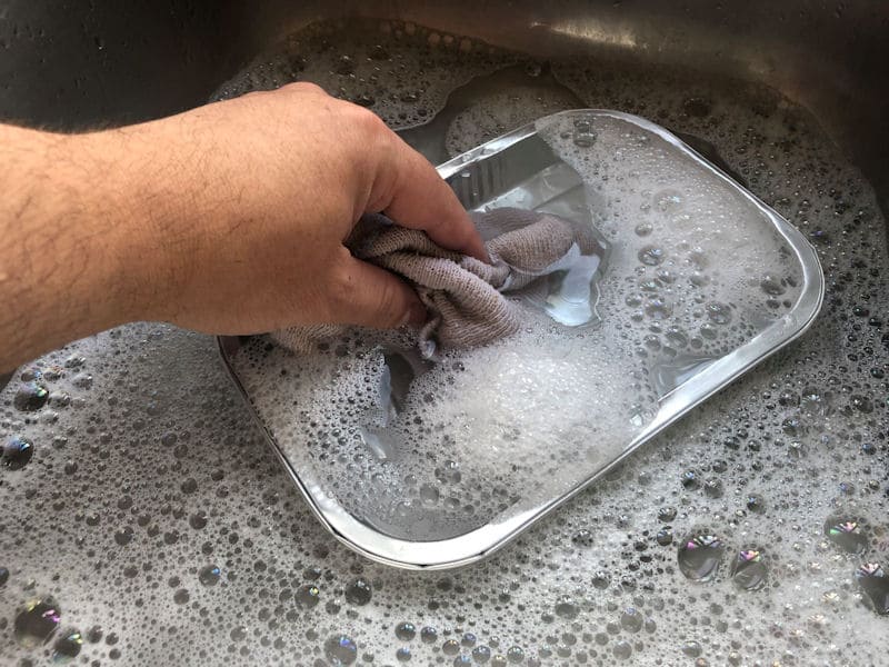 Me washing ready meal foil tray in sink