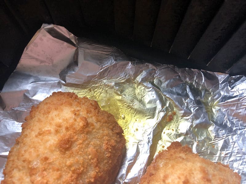 Chicken 
  kiev in air fryer with spilled grease on foil lining