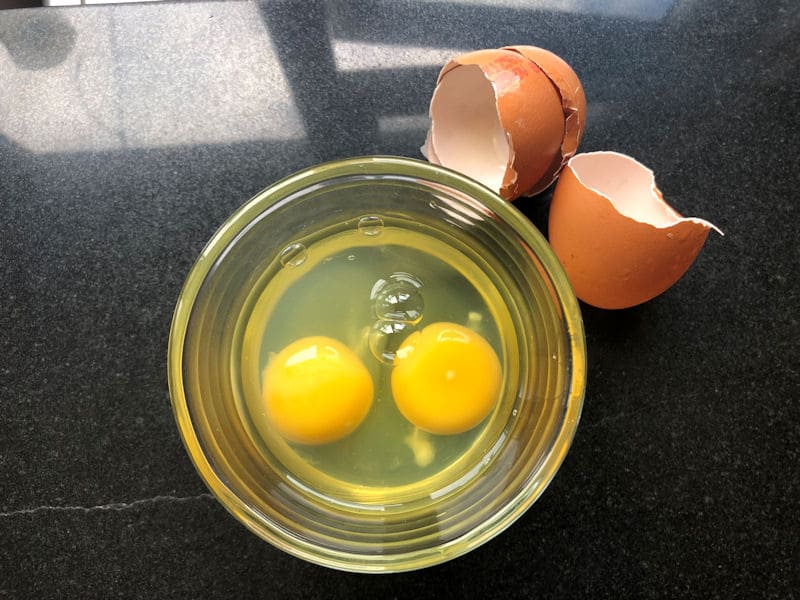 Eggs cracked into a clear ramekin