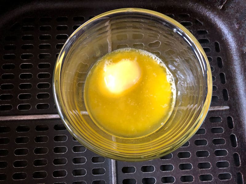 Glass ramekin with melted butter in air fryer