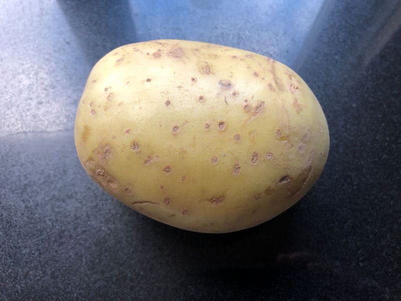 Clean baking potato sat on kitchen worktop