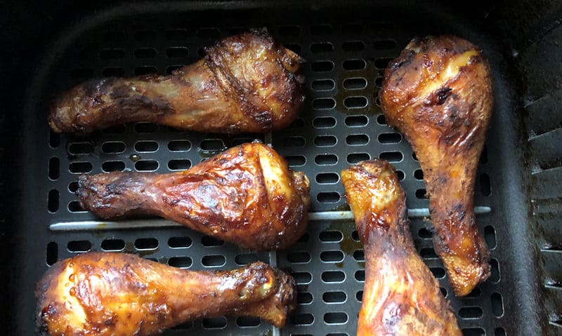 BBQ chicken drumsticks evenly spaced in air fryer basket