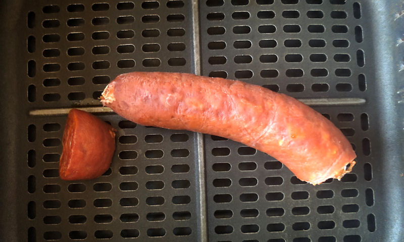 Chorizo half ring, plus extra chunk, sitting in air fryer basket