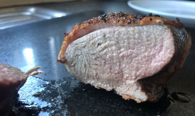 Medium done air fried duck breast, cut in half on chopping board