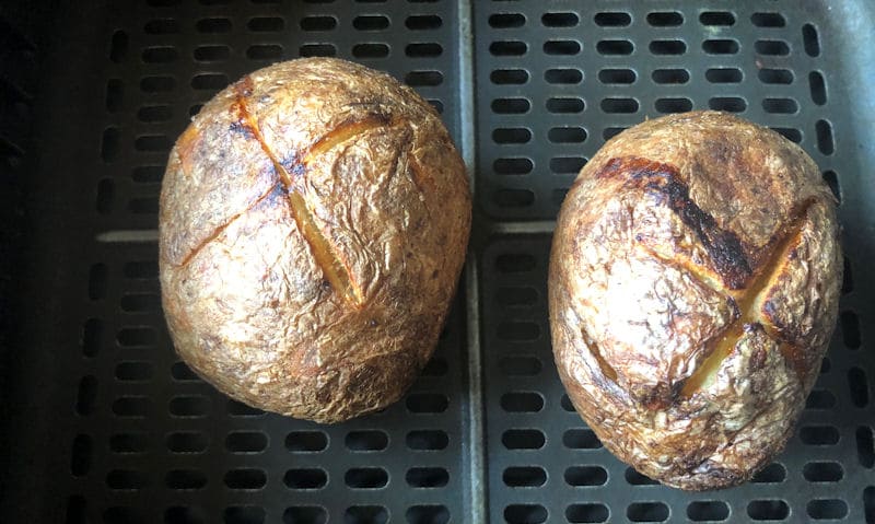 Cooked McCain jacket potatoes sitting in air fryer basket