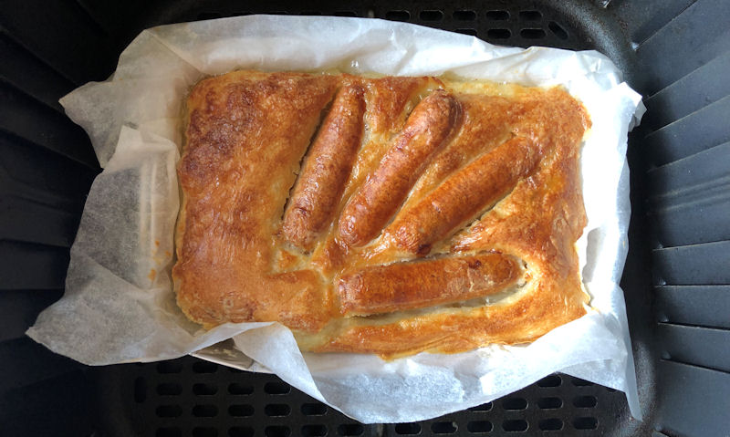 Fully cooked Tesco frozen Toad in the Hole sitting in air fryer basket