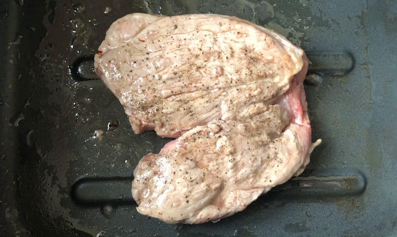 Air fried Lamb Leg Steak sitting in bottom of air fryer outer container