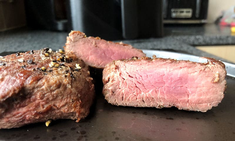 Cut open medium air fried Ostrich steak fillets served on plate