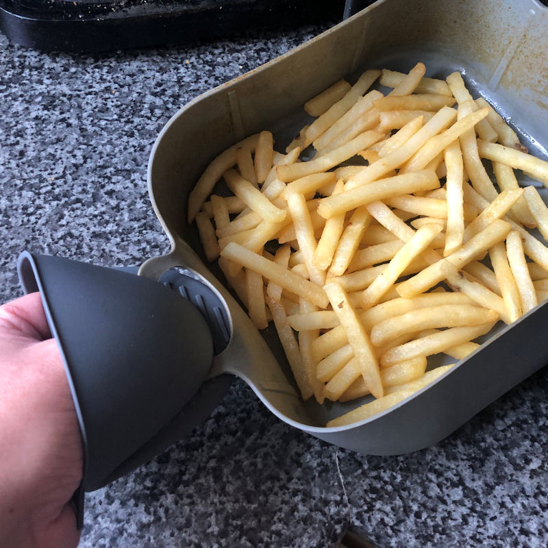 Silicone gloves are used to pull pot out of air fryer basket