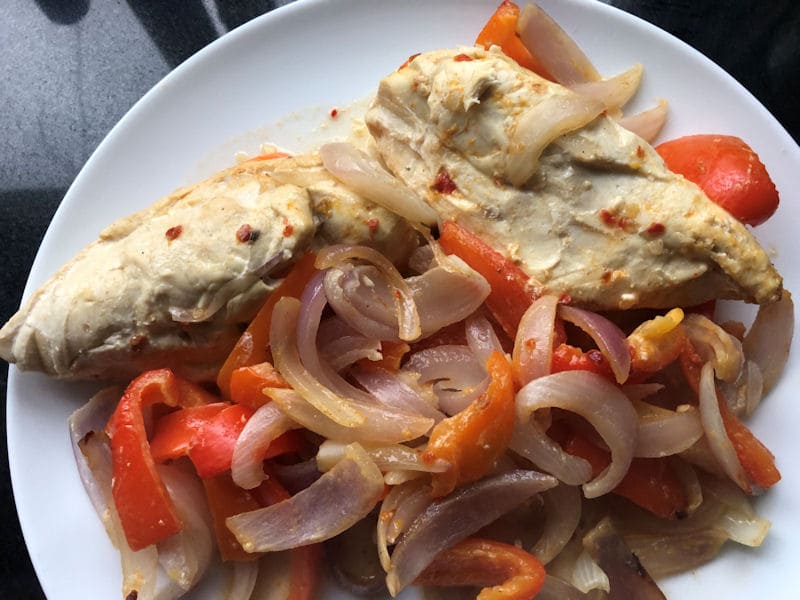 Plated Maggi chicken breasts with mixed onion and peppers