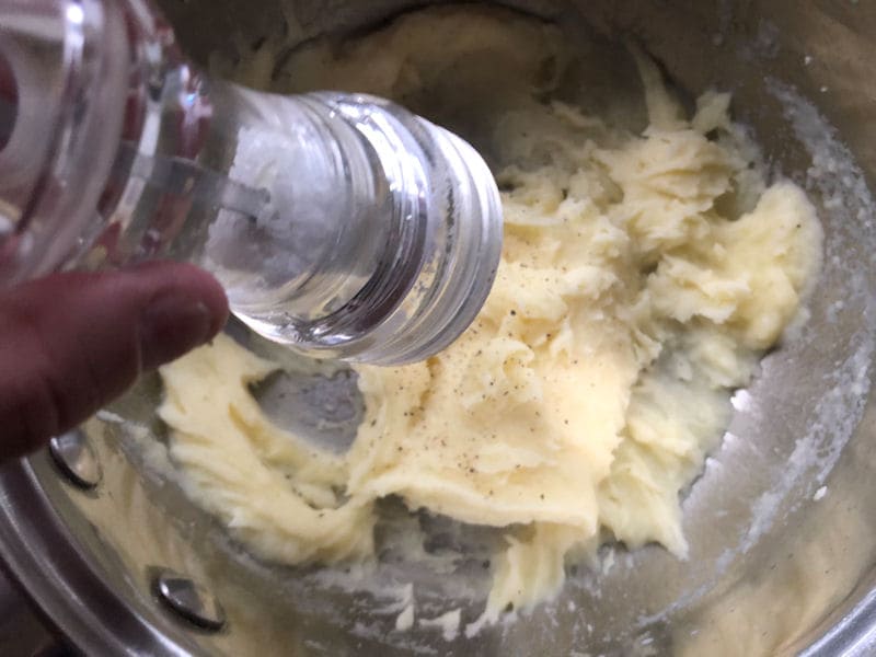 Milk poured over mashed potato in saucepan