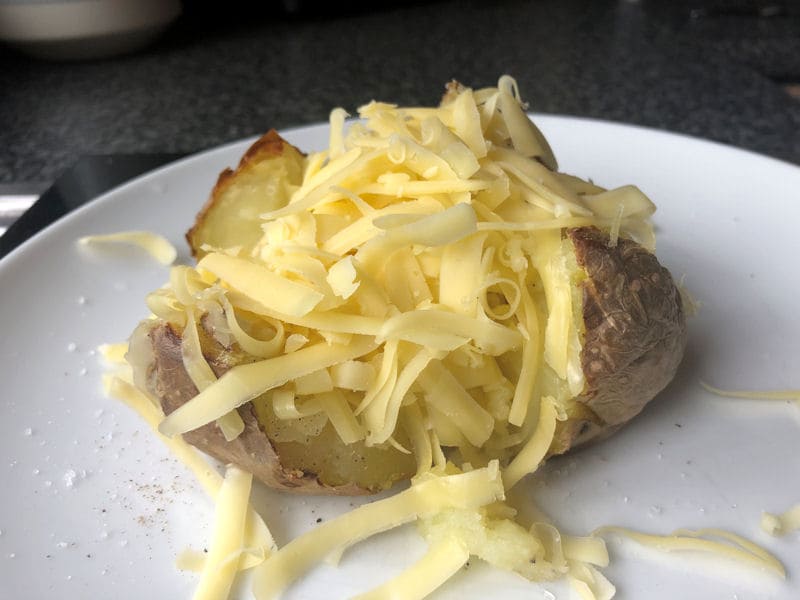 Microwave to air fryer jacket potato served with butter and grated cheese