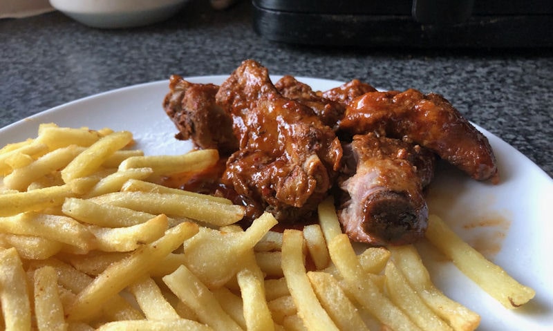 Plate of pre-cooked ribs with French fries