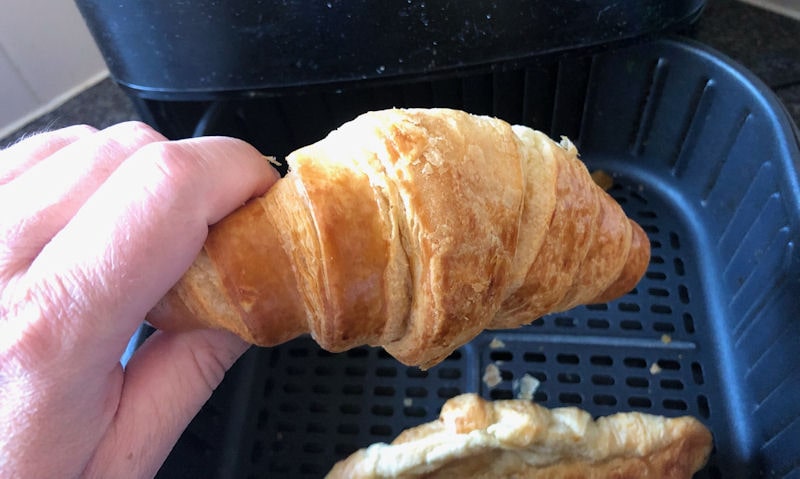 Croissant pulled out of the basket, holding onto in my hand