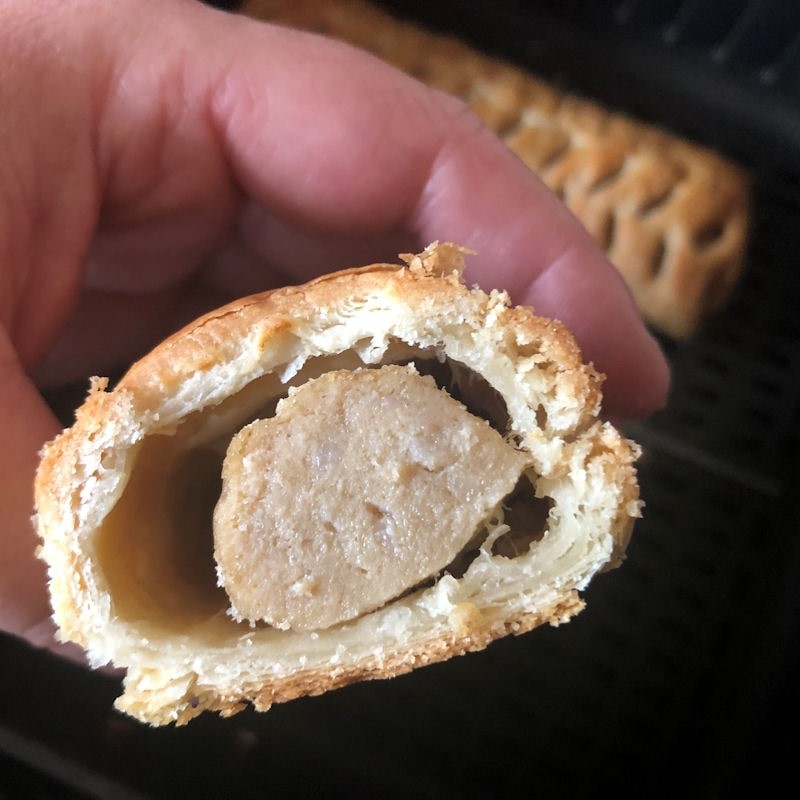 Me holding cut open sausage roll up close to camera