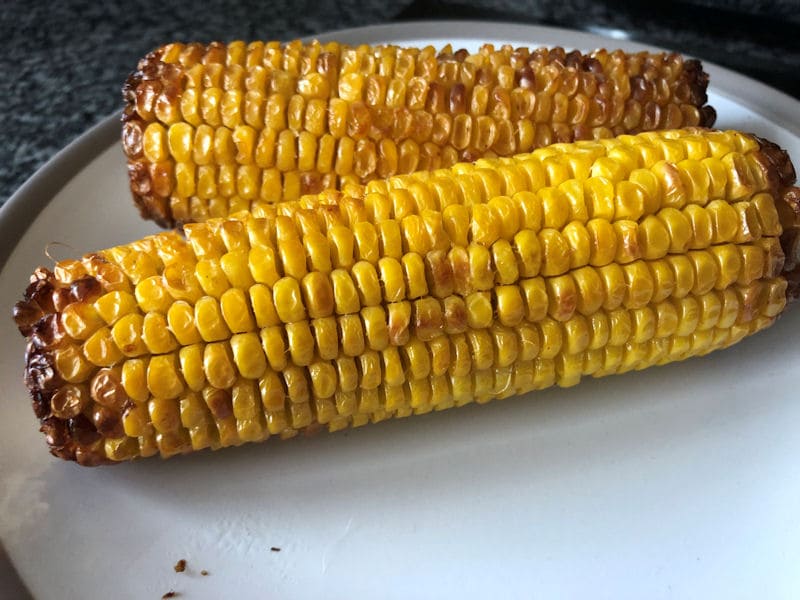 Air fried roasted corn on the cobs resting on dinner plate