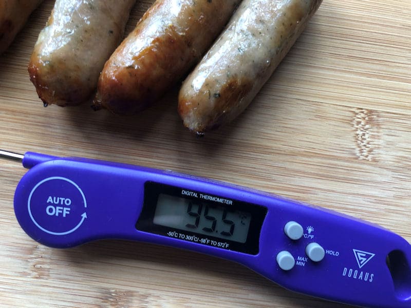 Food
thermometer next to air fried sausages on wooden chopping board