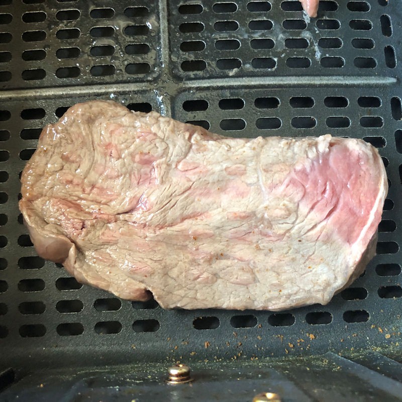 Badly seared Sizzle Steak in air fryer basket