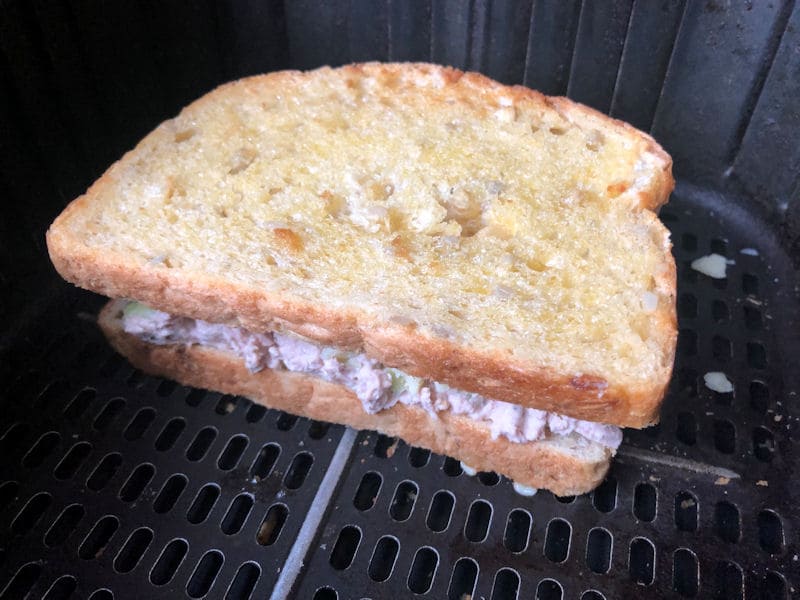 Partially air fried assembled tuna melt sandwich inside air fryer